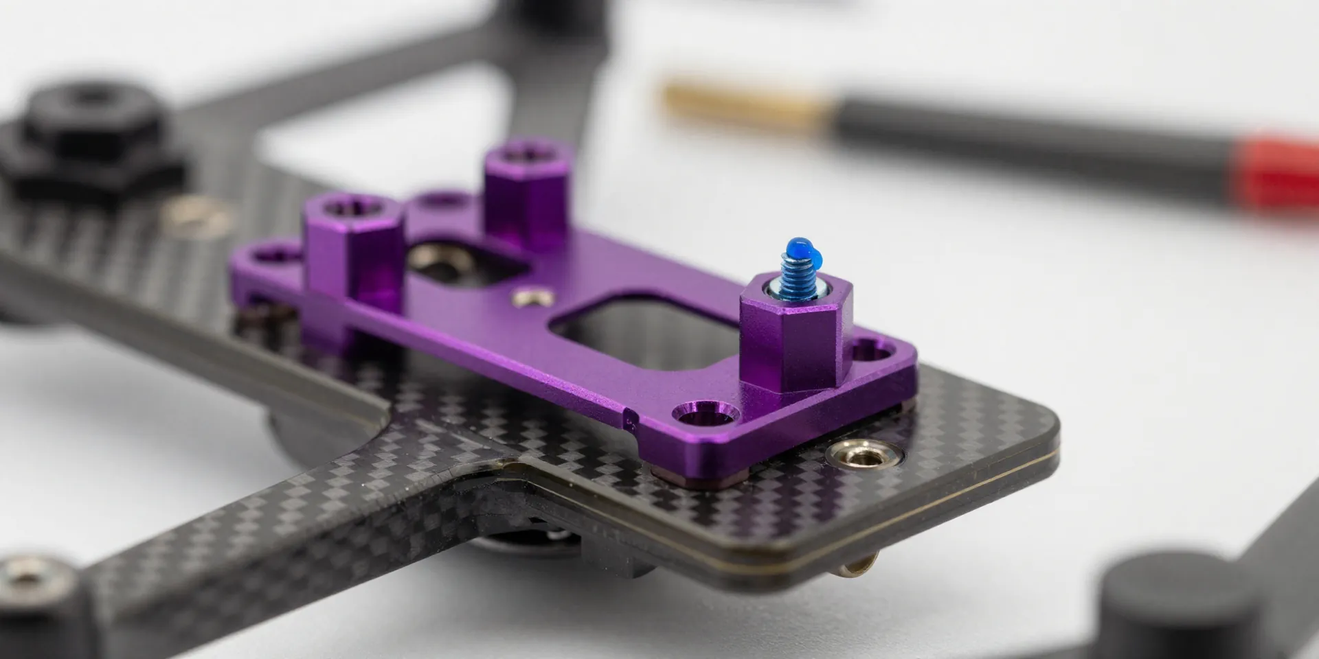 Close up shot of purple aluminum standoffs attached to a carbon fiber bottom plate of a drone, a small drop of blue threadlocker on a screw, shallow depth of field, blurred background with tools, 4k resolution --ar 16:9