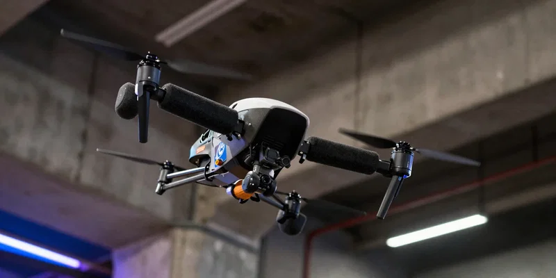 Close up of a heavily customized cinewhoop drone with thick foam prop guards flying close to a parkour athlete mid-jump, urban concrete environment, neon and street lights, dynamic angle, high contrast, photorealistic --ar 16:9 --v 6.0