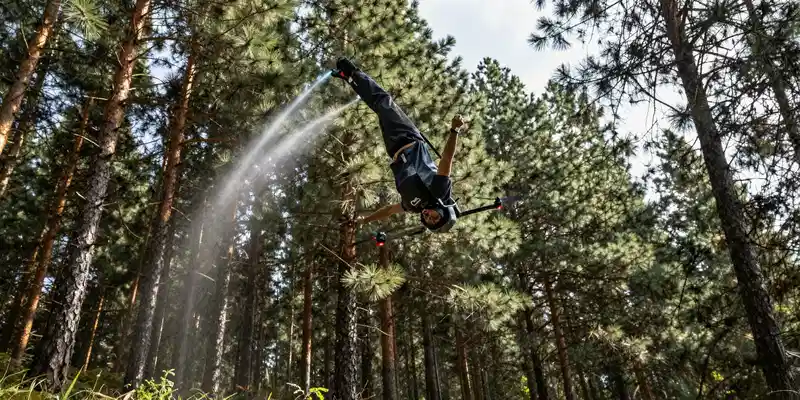 FPV drone diving upside down over a line of pine trees, motion trails, aggressive angle, cinematic action photography, vibrant colors, hyper-detailed --ar 16:9