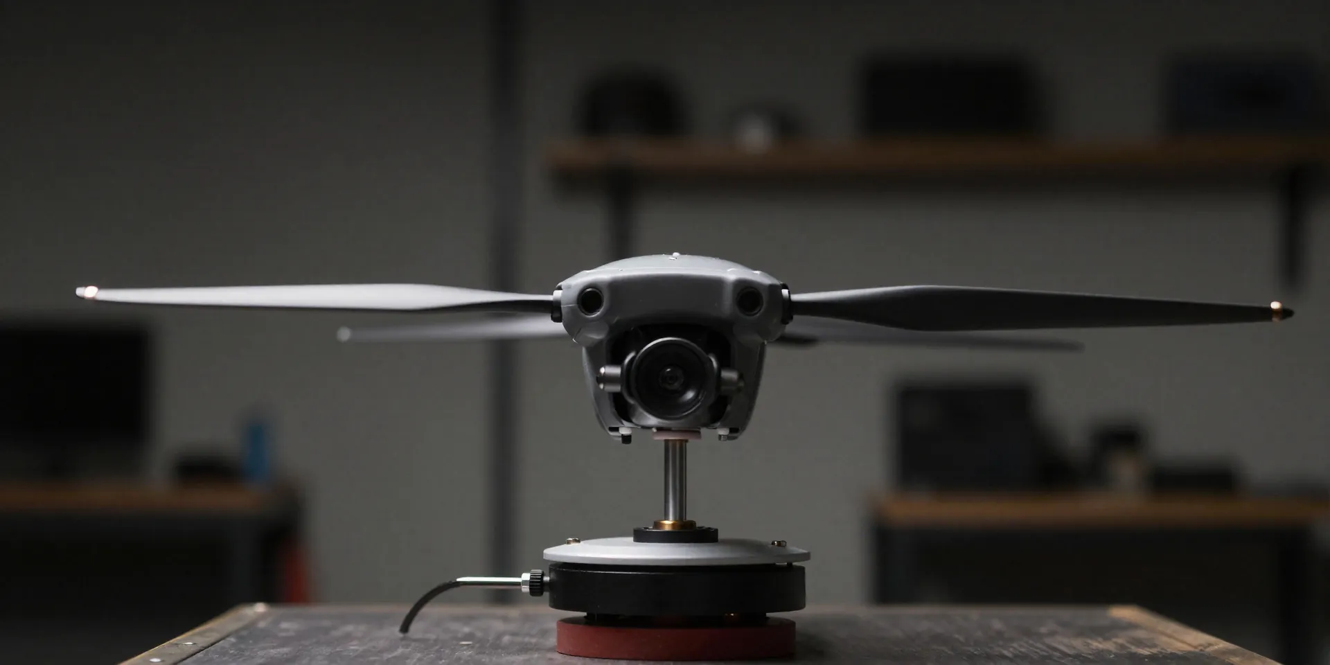 A two-blade drone propeller suspended perfectly horizontal on a magnetic balancer, shallow depth of field, focused on the central shaft, moody garage workshop background, realistic lighting --ar 16:9