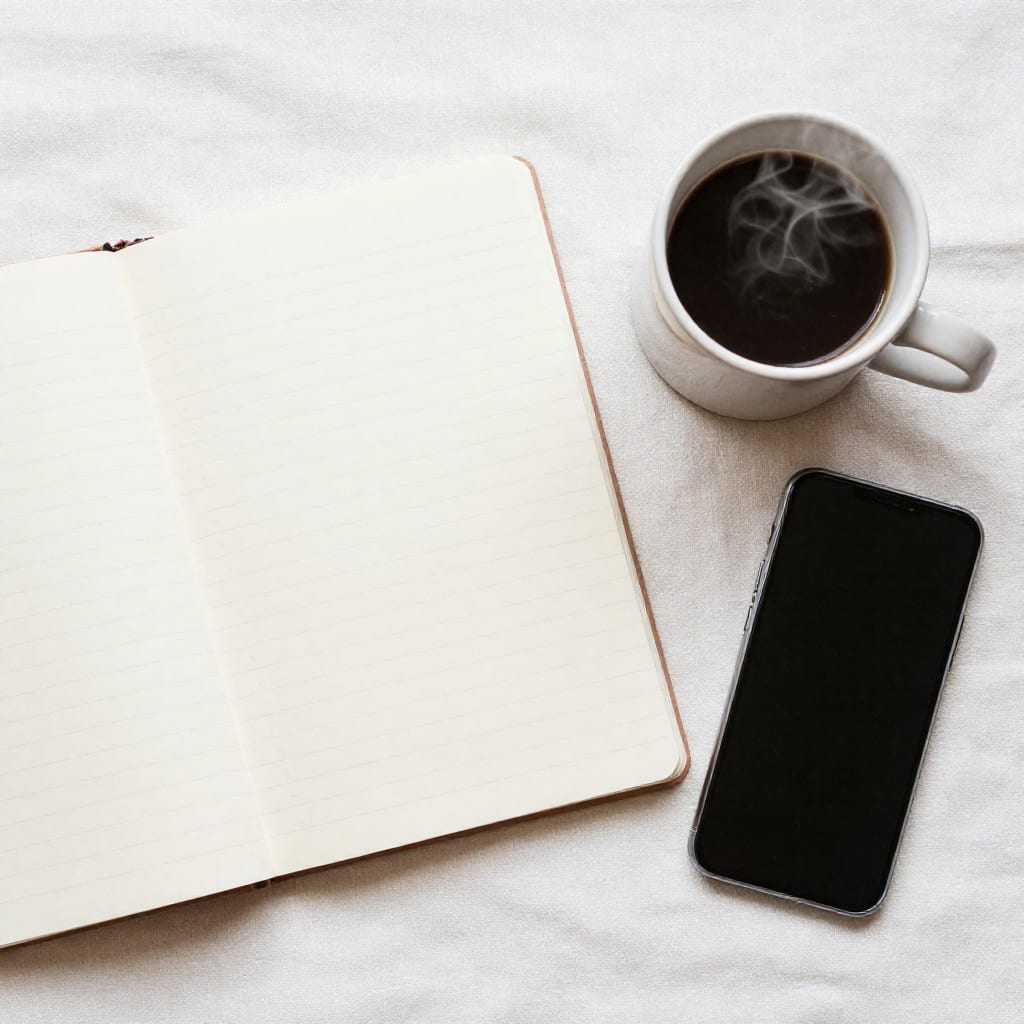 Budget notebook, a ceramic coffee mug, and a smartphone on a linen surface