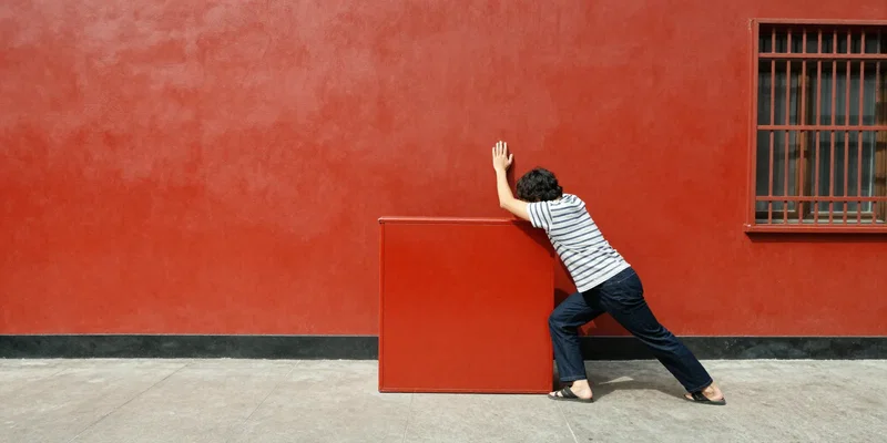 A person firmly pressing a large, retro red 